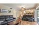 Cozy living room features hardwood floors, modern ceiling fan, and comfortable, oversized seating at 4207 Northwind Ln, Tampa, FL 33624