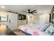 Cozy bedroom featuring a large bed, ceiling fan, TV, and barn door entrance to the ensuite bath at 4207 Northwind Ln, Tampa, FL 33624