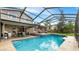 Private screened-in pool featuring a stone patio, covered seating, and a tranquil backyard setting at 4207 Northwind Ln, Tampa, FL 33624