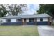 Charming single-story home featuring a freshly painted exterior and mature trees at 4415 Tuna Dr, Tampa, FL 33617