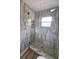 A modern shower featuring marble tile and a glass enclosure at 4415 Tuna Dr, Tampa, FL 33617