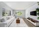 Bright living room boasts hardwood floors, a large window, and a comfortable sofa perfect for relaxing or entertaining guests at 4925 Alcazar S Way, St Petersburg, FL 33712