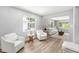 Bright sitting area featuring hardwood floors, a pair of comfortable armchairs, and a spacious open feel at 4925 Alcazar S Way, St Petersburg, FL 33712