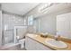 Well-lit bathroom features double sink vanity, shower, and neutral paint at 4928 Timber Way, Zephyrhills, FL 33542