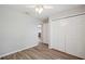 Light and airy bedroom with plank flooring, neutral walls, ceiling fan, and wide closet with double doors at 4928 Timber Way, Zephyrhills, FL 33542