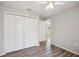 Light and airy bedroom with plank flooring, neutral walls, and wide closet with double doors at 4928 Timber Way, Zephyrhills, FL 33542