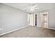 Neutral bedroom offers carpeted floors, ceiling fan, closet, and ensuite bathroom at 4928 Timber Way, Zephyrhills, FL 33542