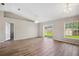 Bright living room with hardwood floors, vaulted ceiling, sliding glass door and natural light at 4928 Timber Way, Zephyrhills, FL 33542