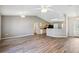 Open-concept living room features hardwood floors, ceiling fan, and a view into the kitchen at 4928 Timber Way, Zephyrhills, FL 33542