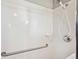Updated shower featuring white tiling, grab bar, and a handheld shower head fixture at 4928 Timber Way, Zephyrhills, FL 33542