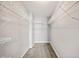 Spacious walk-in closet features neutral paint and shelving racks for organization at 4928 Timber Way, Zephyrhills, FL 33542