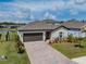 Aerial view of a charming home with a brick driveway and manicured lawn in a suburban neighborhood at 5329 Senza Trl, Palmetto, FL 34221