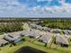 Aerial view of the back of a home with a fenced yard, view of the pond, and well-manicured lawn at 5329 Senza Trl, Palmetto, FL 34221
