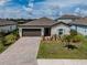 Well maintained home features a brick driveway, manicured lawn and a lush garden at 5329 Senza Trl, Palmetto, FL 34221