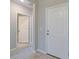 Bright hallway featuring a white front door and wood-look tile flooring at 5329 Senza Trl, Palmetto, FL 34221