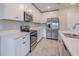 Close up view of kitchen with stainless steel appliances and white cabinets and stone counter tops at 5329 Senza Trl, Palmetto, FL 34221