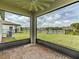A screened-in lanai with brick flooring, a ceiling fan, and a view of the lake at 5329 Senza Trl, Palmetto, FL 34221