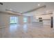 Open concept living space with kitchen, hardwood floors, natural light from windows and sliding doors at 5329 Senza Trl, Palmetto, FL 34221