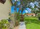 A peaceful outdoor view showing meticulously kept lawn, mature trees, and a glimpse of a refreshing community pool at 5785 Gardens Dr, Sarasota, FL 34243