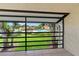Relaxing screened balcony showcasing views of a community pool and mature trees at 5785 Gardens Dr, Sarasota, FL 34243