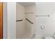 Bathroom features a tiled shower with handrails, a toilet paper holder, and a grab bar at 5785 Gardens Dr, Sarasota, FL 34243