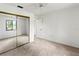 Spacious bedroom with a mirrored closet, neutral carpet, and a ceiling fan at 5785 Gardens Dr, Sarasota, FL 34243