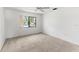 Bright bedroom with a ceiling fan and a large window providing natural light and neighborhood views at 5785 Gardens Dr, Sarasota, FL 34243