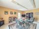 Comfortable seating area with a glass table, and bookshelves with games creates a relaxing place for gathering at 5785 Gardens Dr, Sarasota, FL 34243