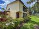 Inviting exterior view of the property showcasing well-maintained landscaping and a charming facade with a screen enclosed porch at 5785 Gardens Dr, Sarasota, FL 34243