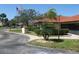 The attractive exterior view features mature landscaping, terracotta-colored roofs, and well-maintained grounds, with visible flags at 5785 Gardens Dr, Sarasota, FL 34243