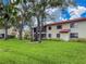 Scenic exterior view of the residential building with mature trees and well-maintained lawn in a lush landscape at 5785 Gardens Dr, Sarasota, FL 34243