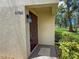 Close-up of the front door with decorative lighting and lush greenery, enhancing the inviting entrance at 5785 Gardens Dr, Sarasota, FL 34243