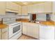 Traditional kitchen featuring wood countertops, white appliances and cabinets, and tile flooring at 5785 Gardens Dr, Sarasota, FL 34243