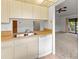 Bright kitchen overlooking the living area, complete with white appliances, and neutral cabinets at 5785 Gardens Dr, Sarasota, FL 34243