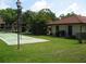 Exterior side view of a community shuffleboard court with the clubhouse in the background at 5785 Gardens Dr, Sarasota, FL 34243
