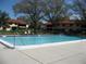 This pristine community swimming pool has lounge chairs and manicured landscaping creating a resort-like atmosphere at 5785 Gardens Dr, Sarasota, FL 34243