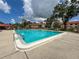 The bright blue pool, surrounded by lounge chairs and greenery, offers a refreshing oasis on a sunny day at 5785 Gardens Dr, Sarasota, FL 34243