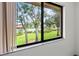 Bright window view overlooking a well-manicured lawn and community pool at 5785 Gardens Dr, Sarasota, FL 34243