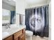 Bright bathroom featuring a vanity, toilet, and shower with a decorative space-themed curtain at 5830 100Th E Ave, Parrish, FL 34219
