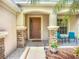 Covered entryway showcasing stone pillars, blue chairs, and decorative landscaping at 5830 100Th E Ave, Parrish, FL 34219