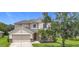 Charming two-story home with landscaped yard, two-car garage, and inviting front porch seating at 5830 100Th E Ave, Parrish, FL 34219