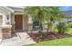 Inviting front porch features stone accents, a cozy seating area, and lush landscaping at 5830 100Th E Ave, Parrish, FL 34219