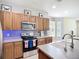 Well-lit kitchen with stainless steel appliances, breakfast bar and tile backsplash at 5830 100Th E Ave, Parrish, FL 34219