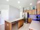 Kitchen island with stainless steel dishwasher and wooden cabinets and stainless steel refrigerator at 5830 100Th E Ave, Parrish, FL 34219
