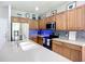 Beautiful kitchen with stainless steel appliances, wooden cabinetry, island, and sink at 5830 100Th E Ave, Parrish, FL 34219