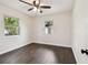 This bedroom features hardwood floors, a ceiling fan, and windows for natural light at 5934 51St N Ave, Kenneth City, FL 33709