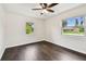 The vacant bedroom has dark hardwood floors, two windows and neutral-colored walls at 5934 51St N Ave, Kenneth City, FL 33709