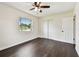 Bedroom with dark wood floors, a ceiling fan, window, and double door closet at 5934 51St N Ave, Kenneth City, FL 33709
