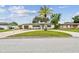 Well-maintained home exterior with a circular driveway, lush lawn, and mature trees, providing a welcoming entrance at 5934 51St N Ave, Kenneth City, FL 33709