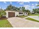 Charming single-story home with a brick driveway, attached garage, and manicured landscaping, offering curb appeal at 5934 51St N Ave, Kenneth City, FL 33709
